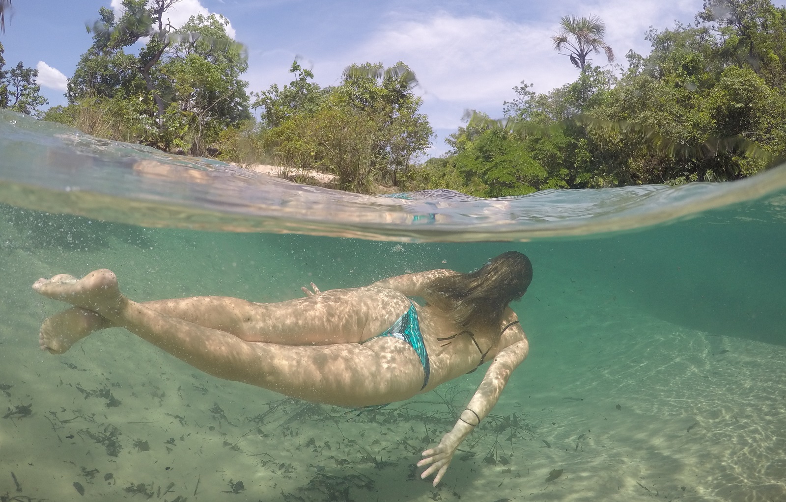 Mulher nadando na praia do Pequizeiro em Aurora do Tocantins, um pedacinho das Serras Gerais