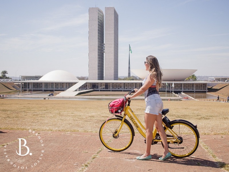 Mulher de perfil  num tour de bike em frente ao congresso nacional em Brasília.